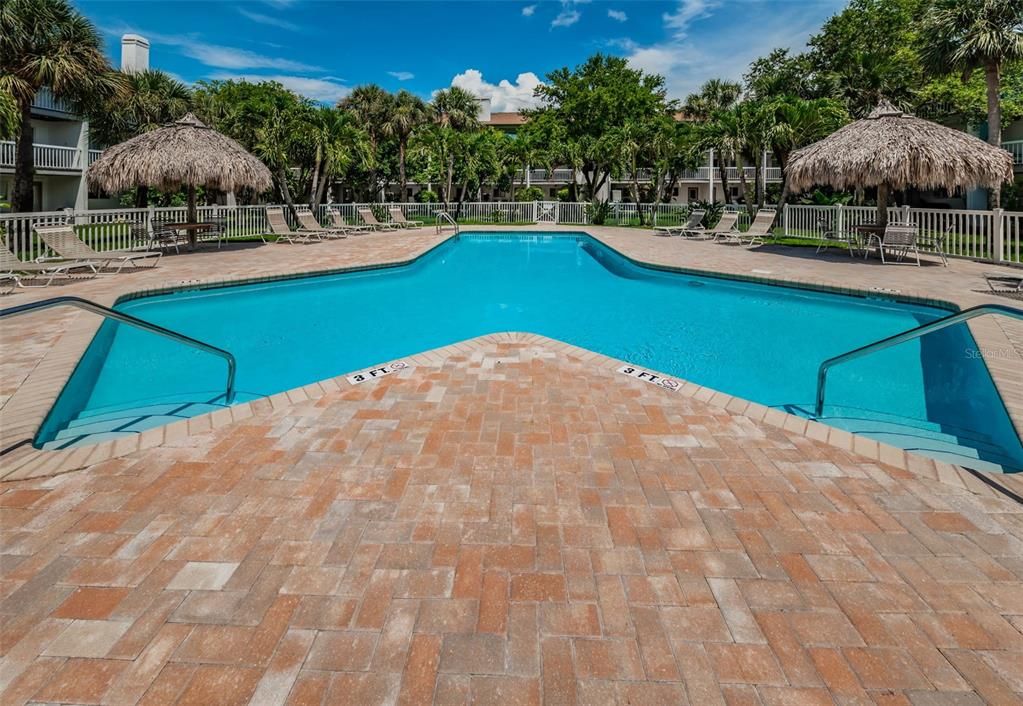 Well maintained pool and pooldeck with ample lounging and covered seating