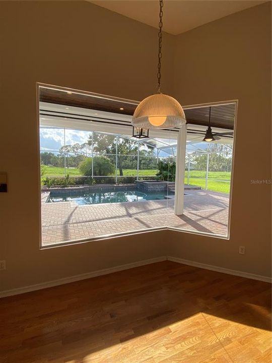 KITCHEN NOOK WINDOW OVERLOOKING GORGEOUS POOL LANAI WITH REMOTE CONTROLLED RETRACTABLE SUN SCREENS