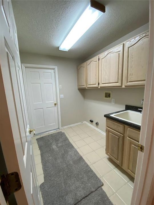 LAUNDRY ROOM WITH GARAGE ENTRY BEYOND