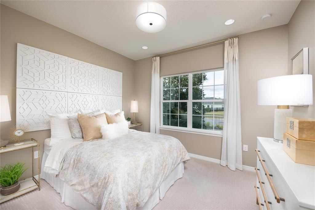 REPRESENTATIVE PHOTO. Lots of natural light with a beautiful neutral color scheme in this secondary bedroom is the perfect place to relax.