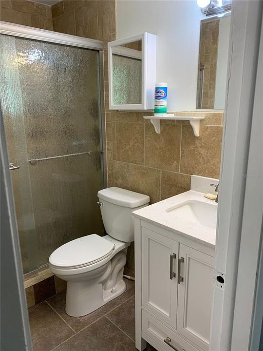 Shared Hallway Tile bathroom with obscure glass frameless glass doors.