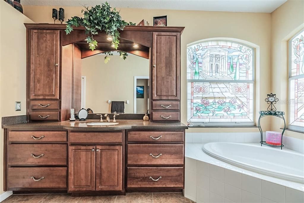 Rich cabinetry in the primary bathroom provides additional storage