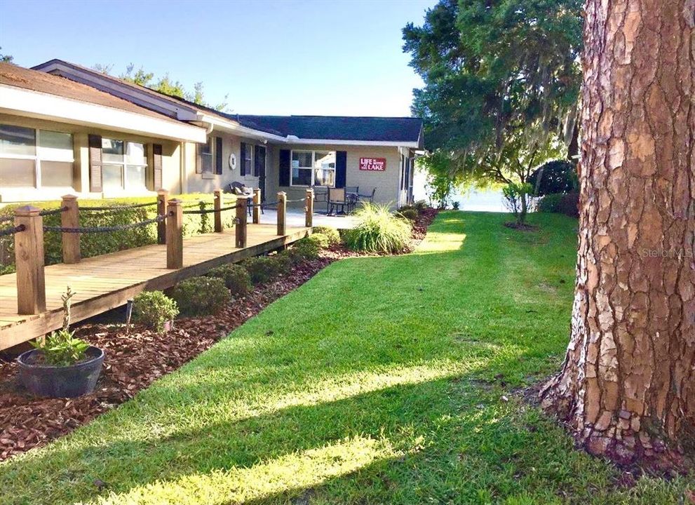 well manicured and landscaped home with plenty of porches
