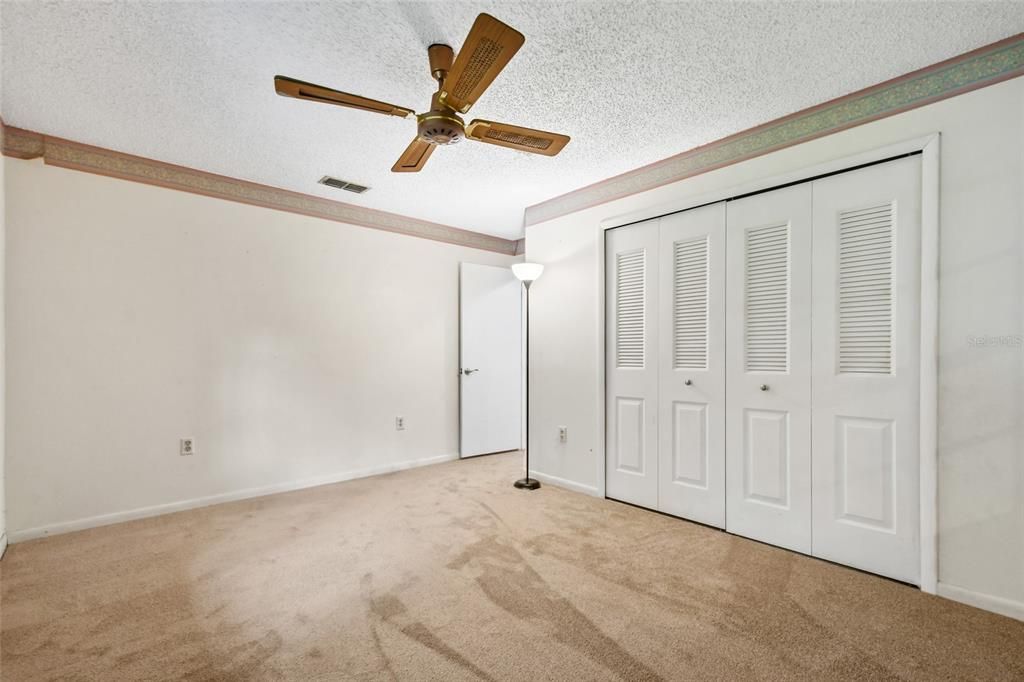 Second bedroom features double closet, new padding and carpet, ceiling fan and new neutral paint.