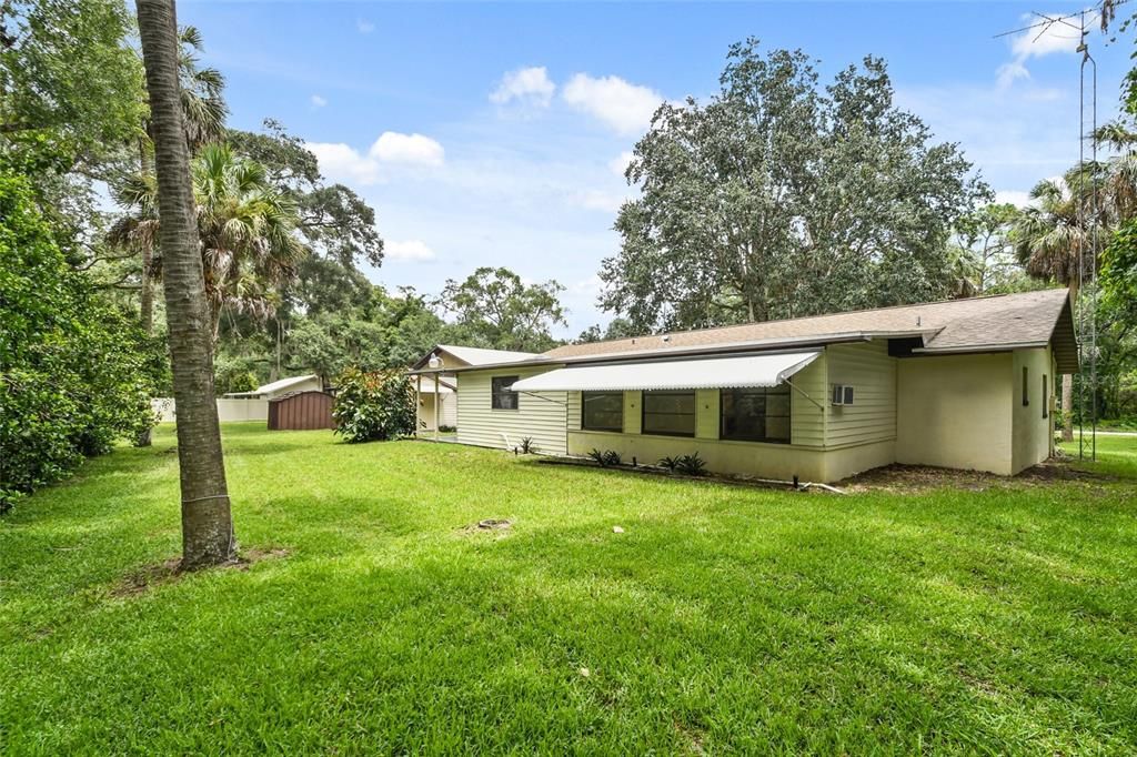 From the left rear corner of the property as you face the home from the front yard you can see the expansive lot , home and out buildings. Even though their is a ton of under roof square footage the yard and greenery are not cramped or congested. Plenty of room for outside entertainment, add pavers and a fire pit, barbecue or a pool.