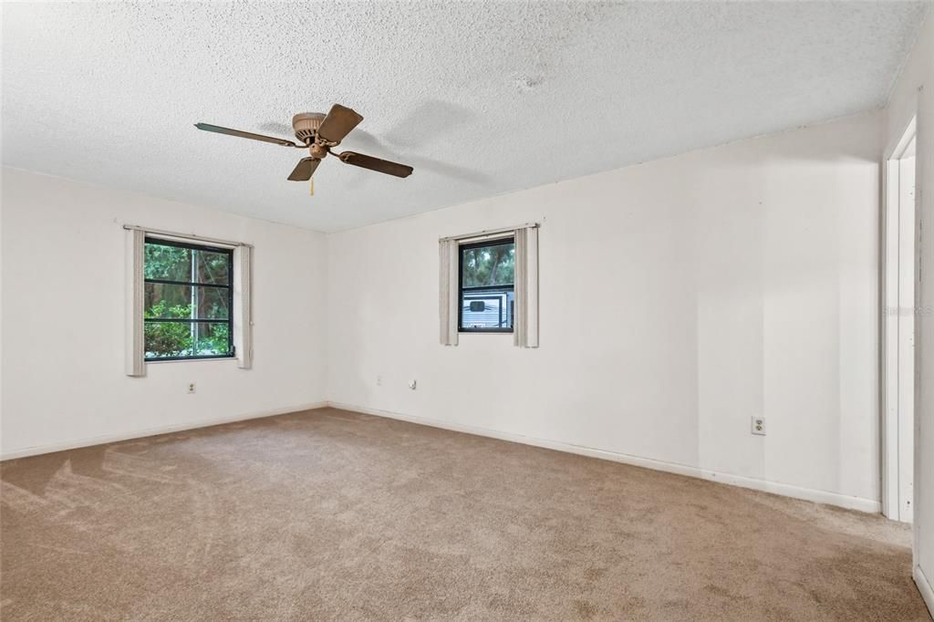 Master bedroom has a total of three windows for a view of the front lawn and  side yard. To the right is the bathroom entrance neutral walls, new carpet and pad and fresh interior paint say ready!