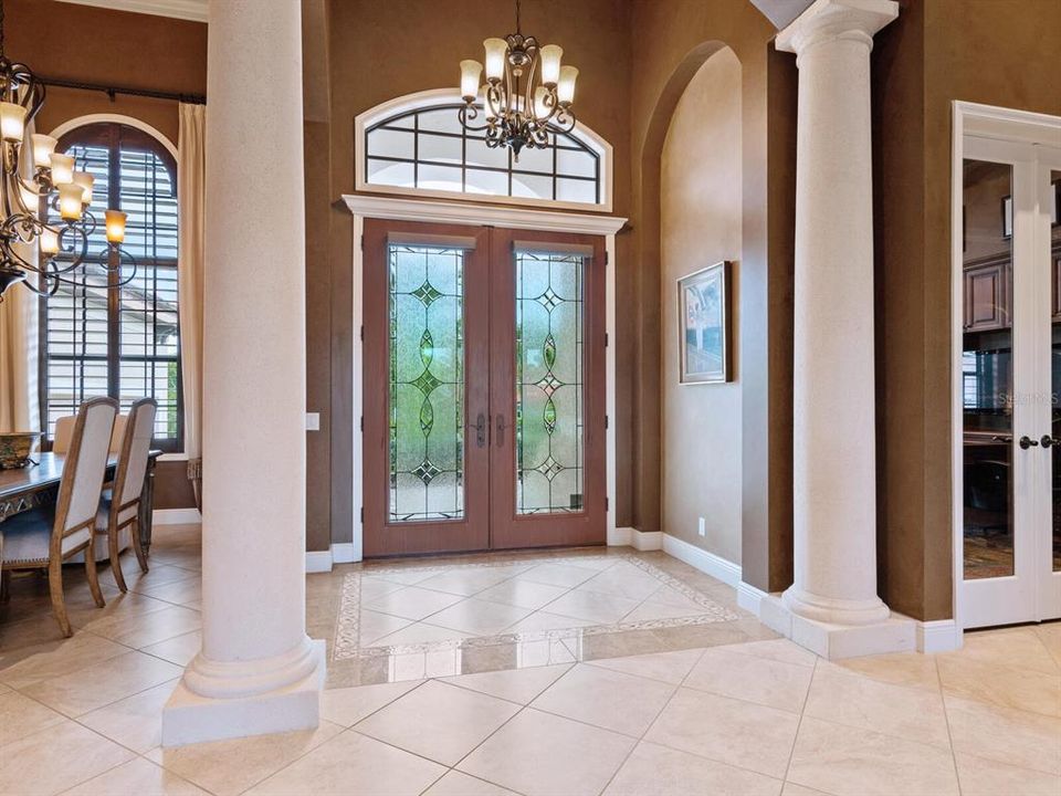 Welcoming spacious foyer with double glass entry and sophisticated architectural details.