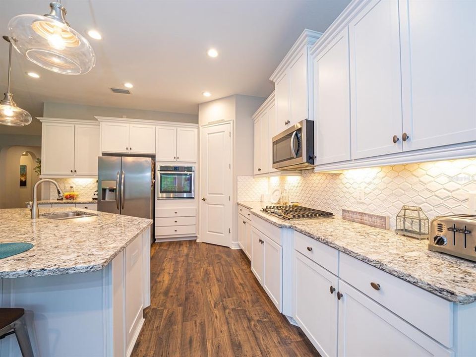 GORGEOUS COUNTERS and backsplash accent the Stunning cabinetry in this Light, Bright Kitchen!
