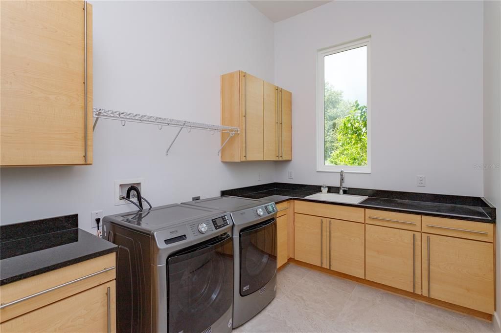 Spacious laundry room with sink and lots of counter and cabinet space