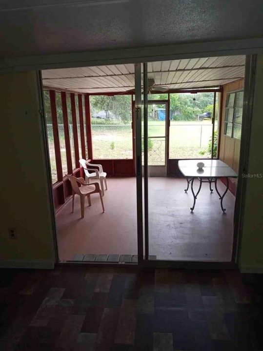 Sliding doors in enclosed porch exit into screened lanai.