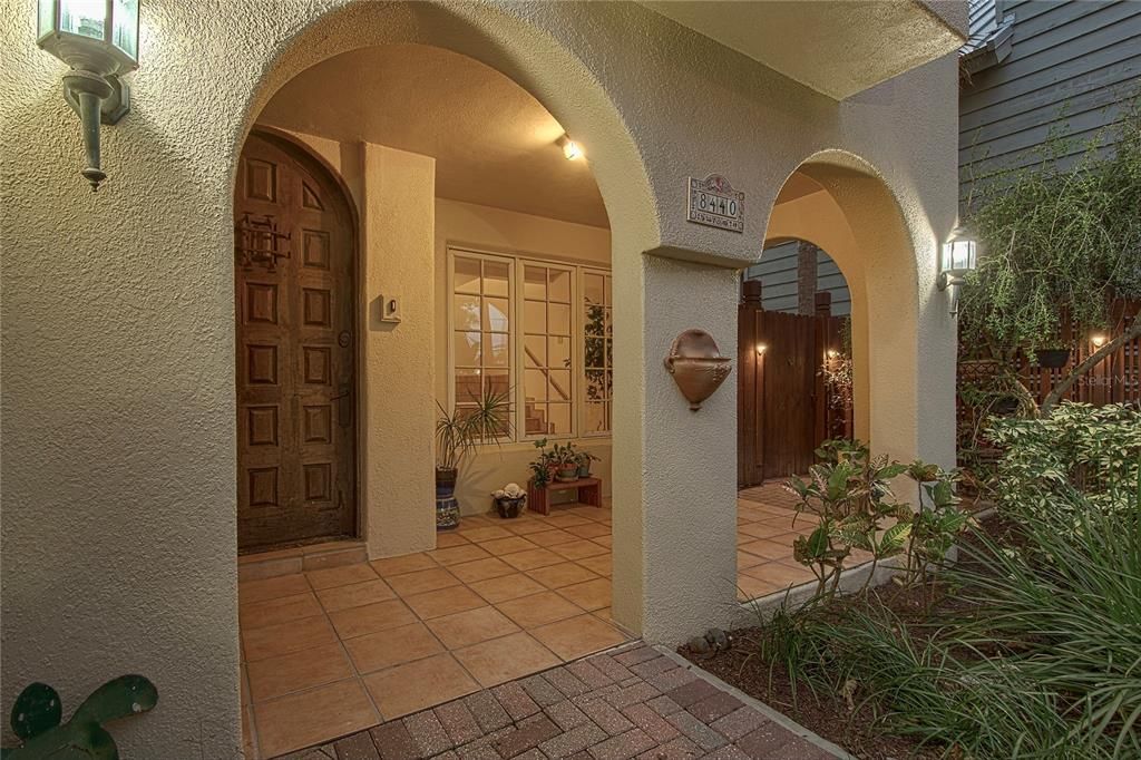 An imported solid heavy oak rustic arched main entry door welcomes you home on the spacious covered front porch.
