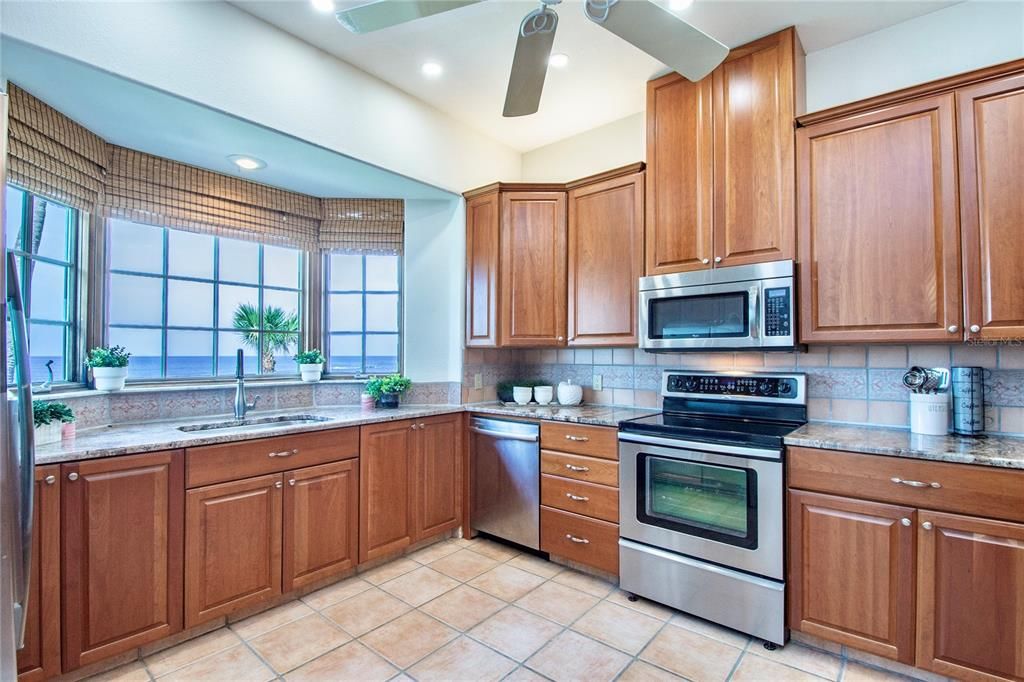 Spacious kitchen with a view and more than enough granite countertop space for many cooks to work together comfortably in the kitchen!