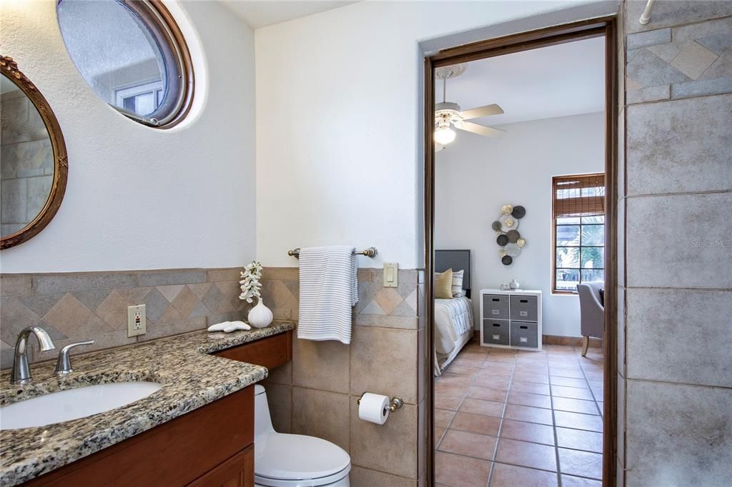 Porthole window provides ambiance in the jack-and-jill bathroom with a tub-shower combo located an main living level between 3rd and 4th bedrooms.