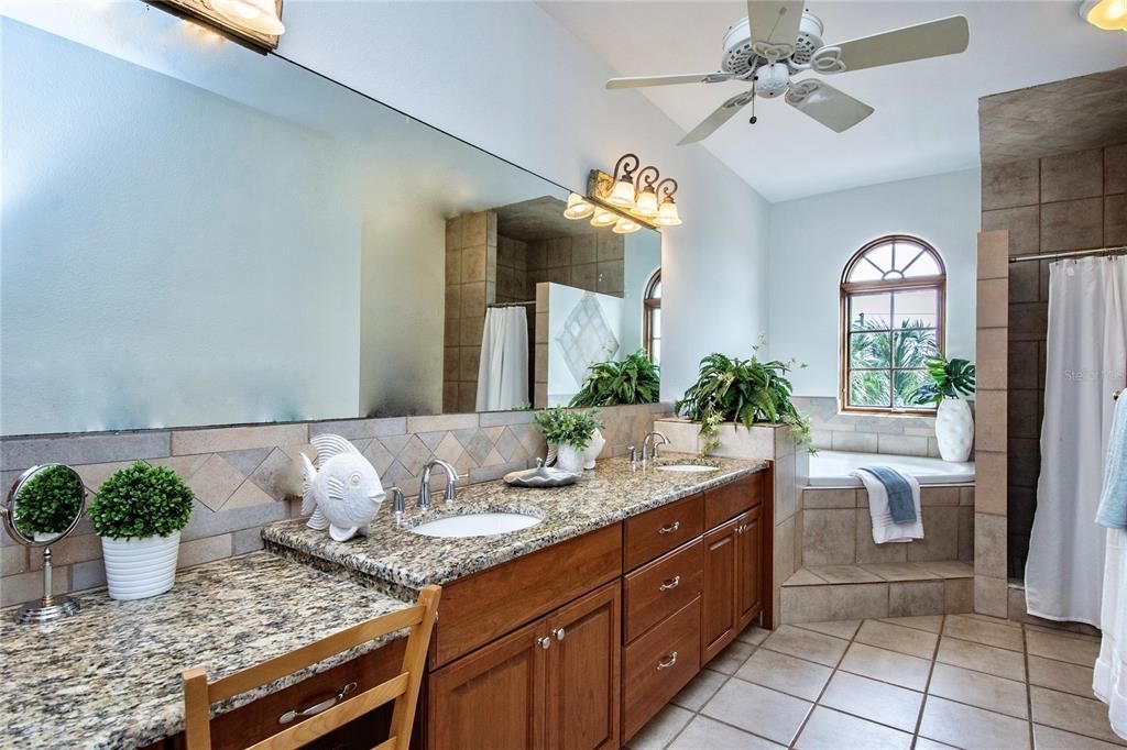 Spacious Owners Suite Bathroom features an arched sunrise window over the jetted garden tub as well as a separate large walk-in shower and linen closet.