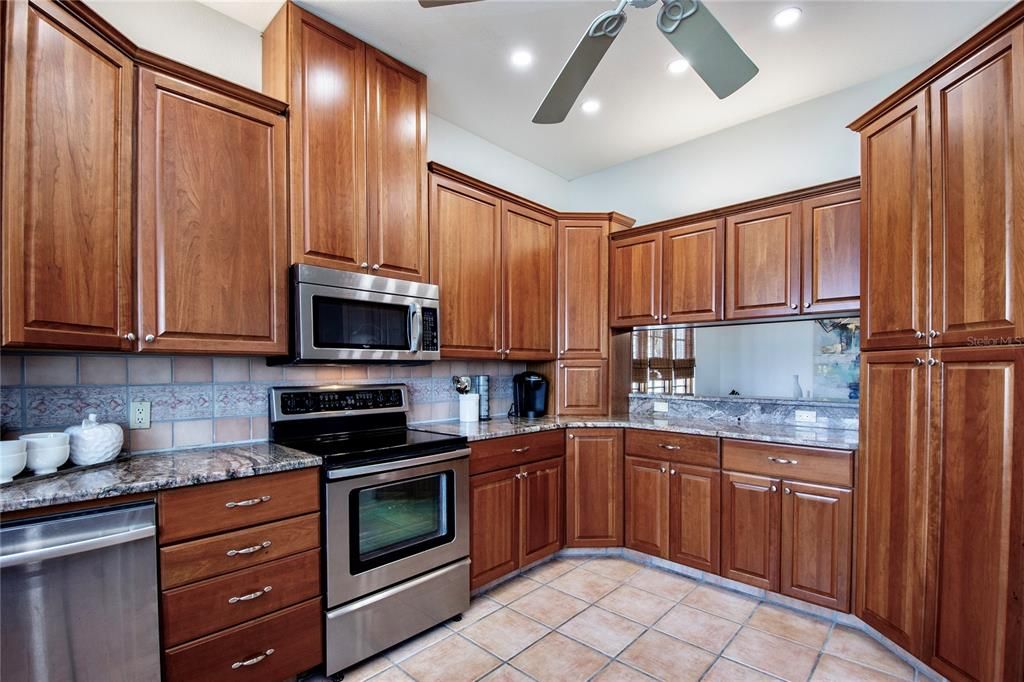 Solid wood 42" cabinetry and pantry offers an abundance of storage in the well appointed kitchen.