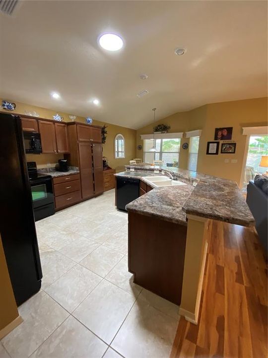 Kitchen has wood cabinets with high definition countertops and  ceramic tile flooring.  Beautiful!
