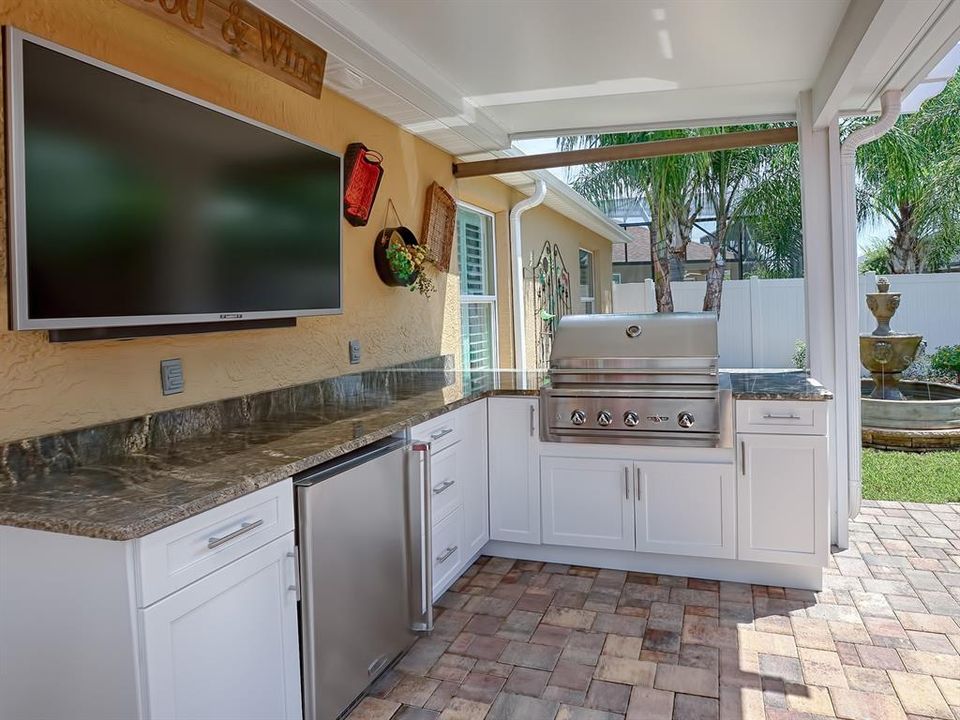 OUTSIDE YOU'LL FIND YOUR NEW SUMMER KITCHEN WITH GRANITE COUNTER TOPS AND SUNBRITE ALL MOUNTED TV -- THE WEATHER CAN'T HURT IT!