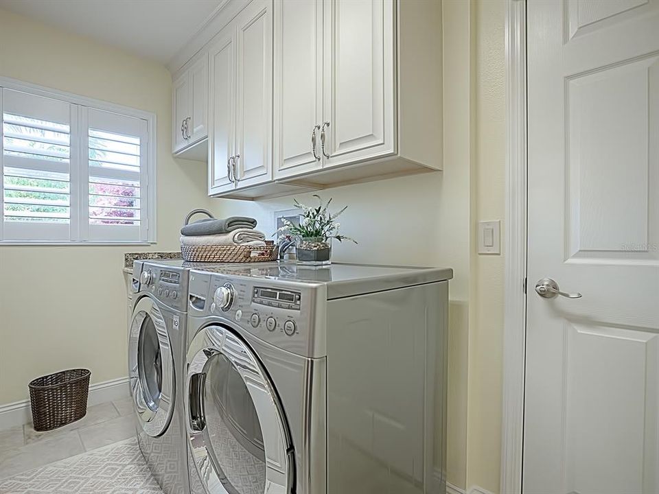 SPACIOUS INSIDE LAUNDRY ROOM WITH A BUILT-IN SINK AND SO MUCH EXTRA CABINET SPACE!