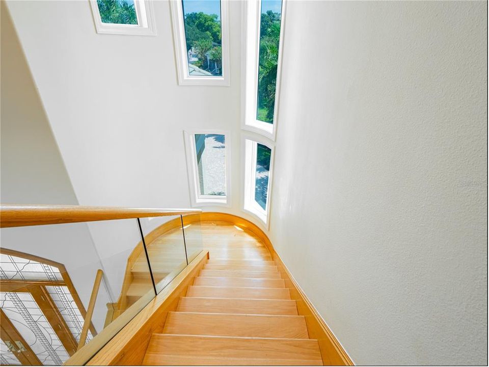 Delight in the high ceilings and windows as you descend the custom, wooden staircase