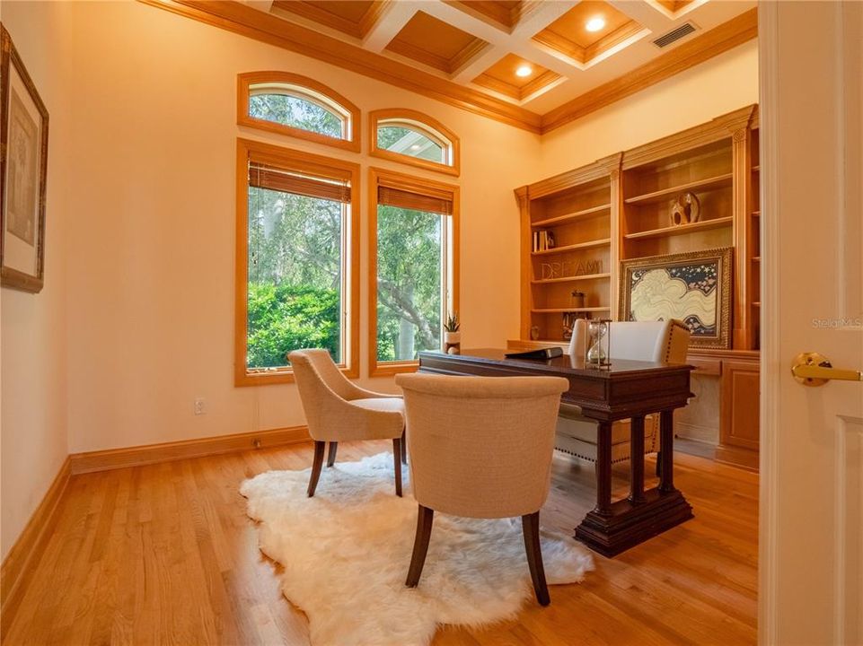 Custom executive home office with coffered ceilings and built-in bookshelves