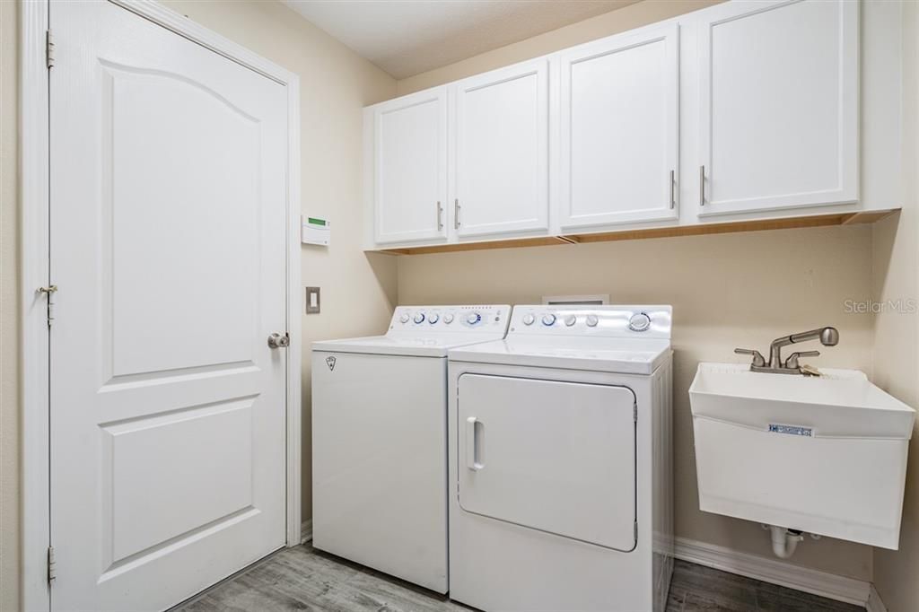 Walk in laundry room with utility sink and built in cabinets