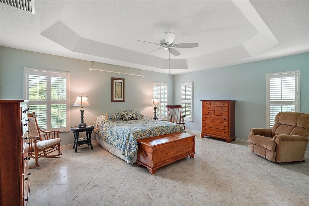 Master bedroom with tray ceiling and tile flooring