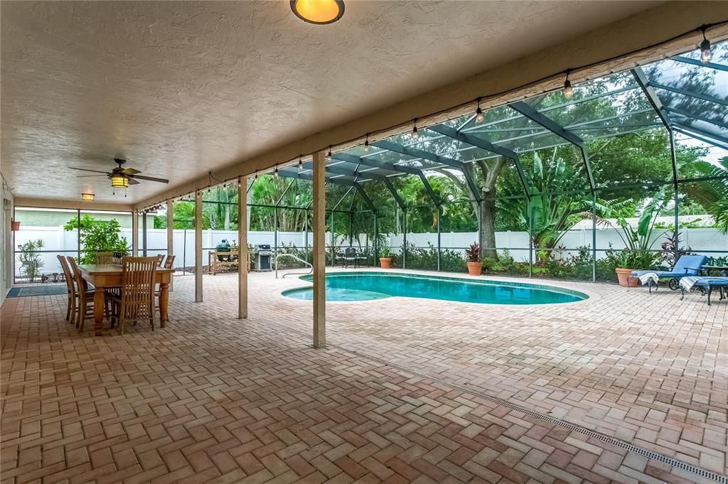 Spacious patio and pool area for entertaining along with beautiful lush green space and landscaping