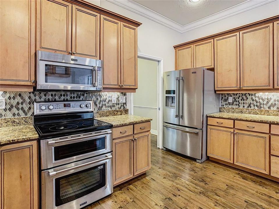 Maytag Stainless Steel Appliances surrounded by beautiful cabinetry.