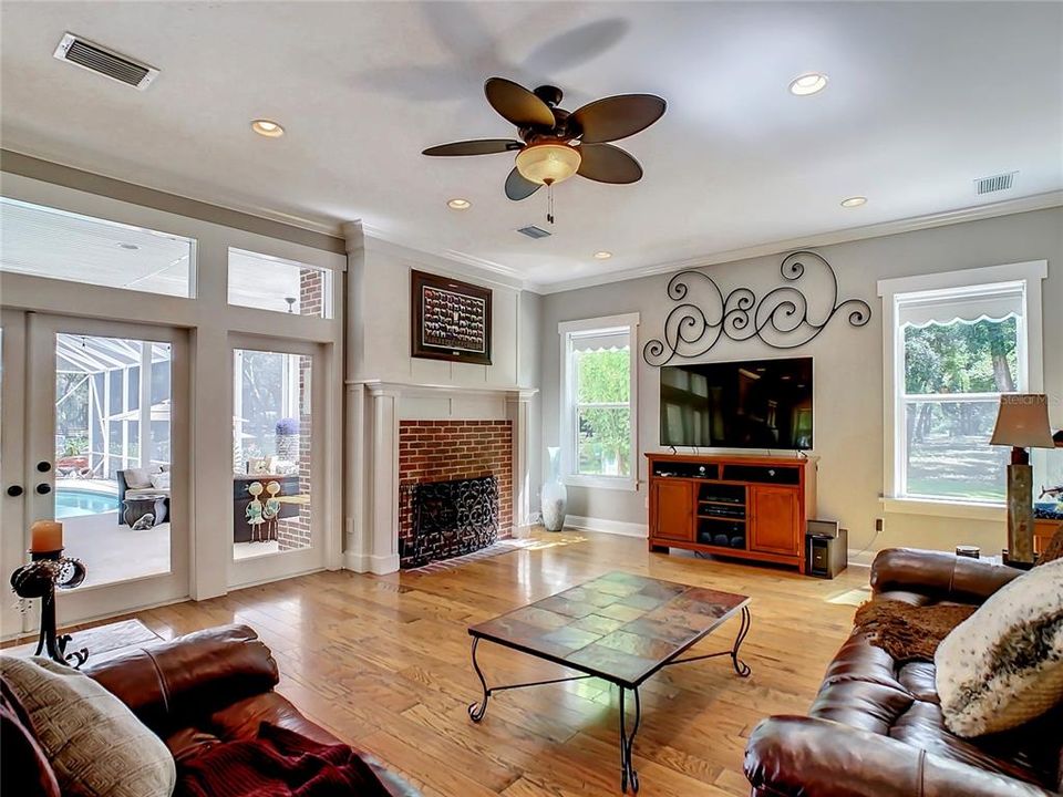 Large and inviting family room has a brick fireplace and French Doors w/ transom windows and sidelights