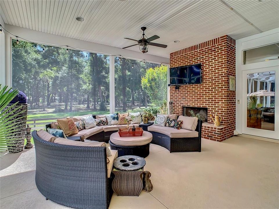 Outdoor living room with floor to ceiling brick fireplace - 100% screened in - so bugs won't irritate you and your guests