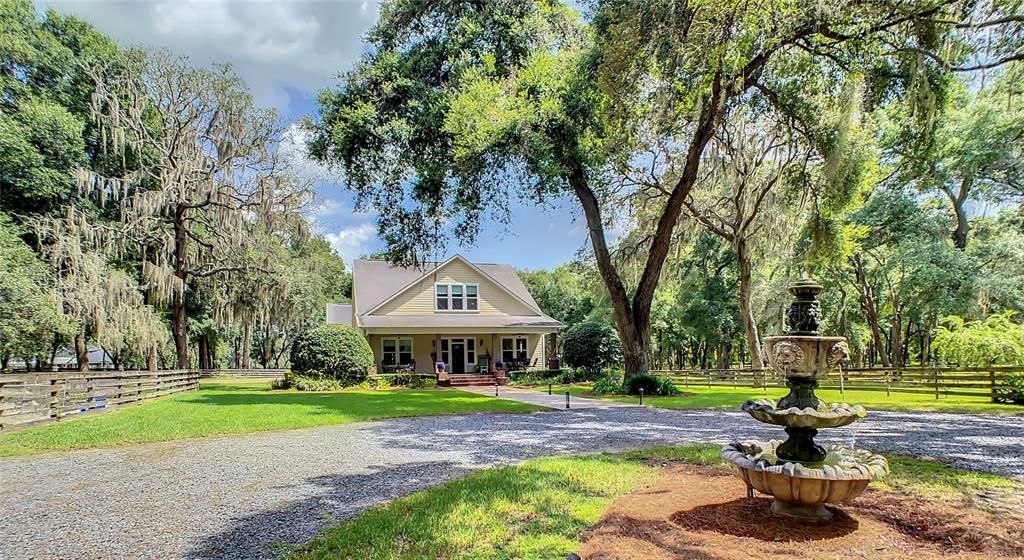 Stunning circular driveway leads to majestic triple tier stone fountain - beautiful low voltage lighting along paver path leading to a beautiful, welcoming front porch