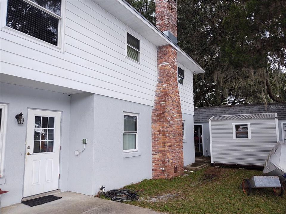 South Facing side of home with small shed.