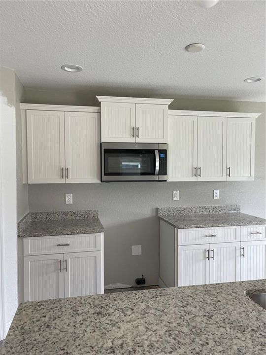 Full suite of stainless steel appliances and granite countertops.