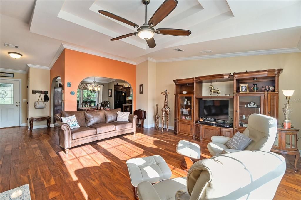 Acacia hardwood flooring, coffered ceiling, crown molding, arches define rooms