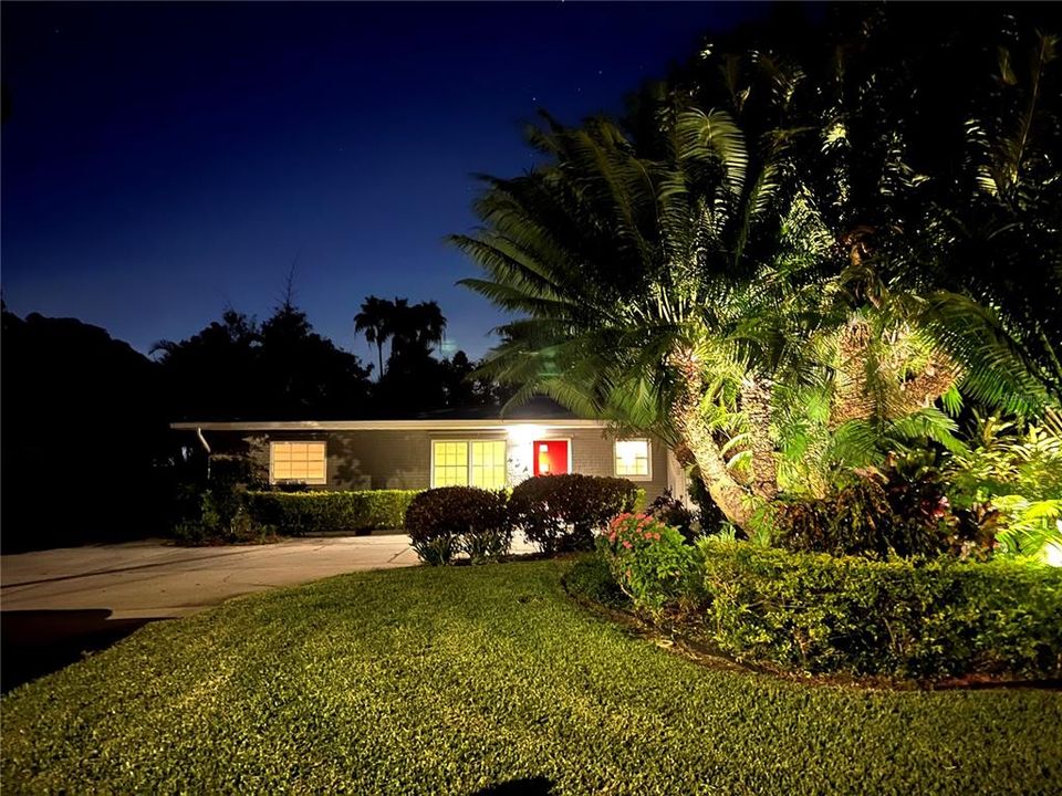 Professional landscape lighting surrounds the home.