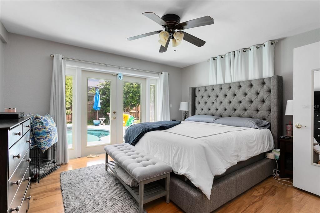 The STUNNING master bedroom features French doors for private pool access.