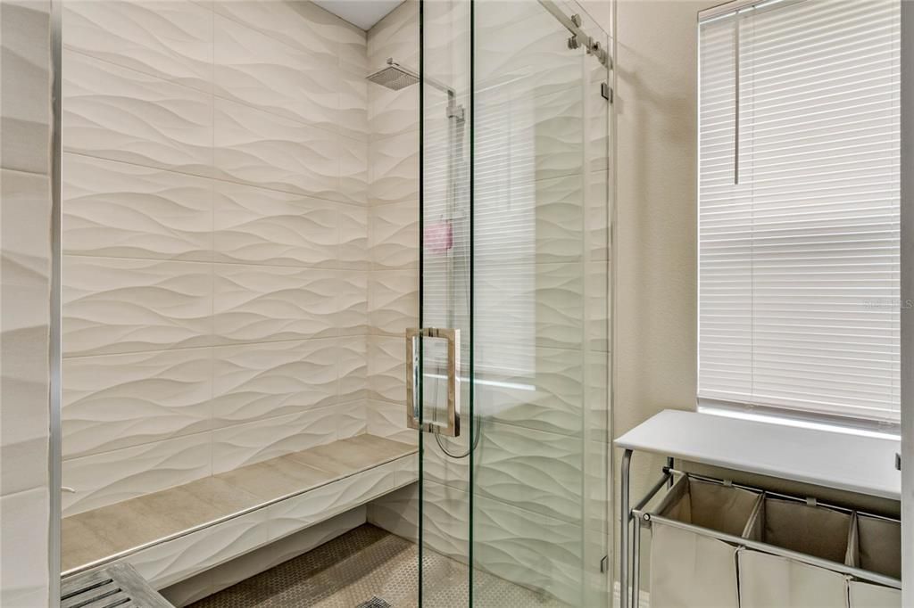 UPDATED EN-SUITE with a MODERN VANITY & LIGHT FIXTURES and a Floor to Ceiling decorative TILE SHOWER with BUILT-IN BENCH, RAIN SHOWER and a FRAMELESS SLIDING GLASS DOOR!