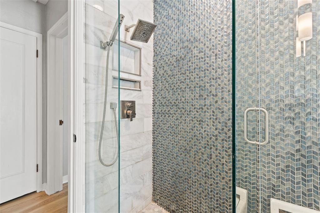Spacious walk in guest shower with more custom accents.