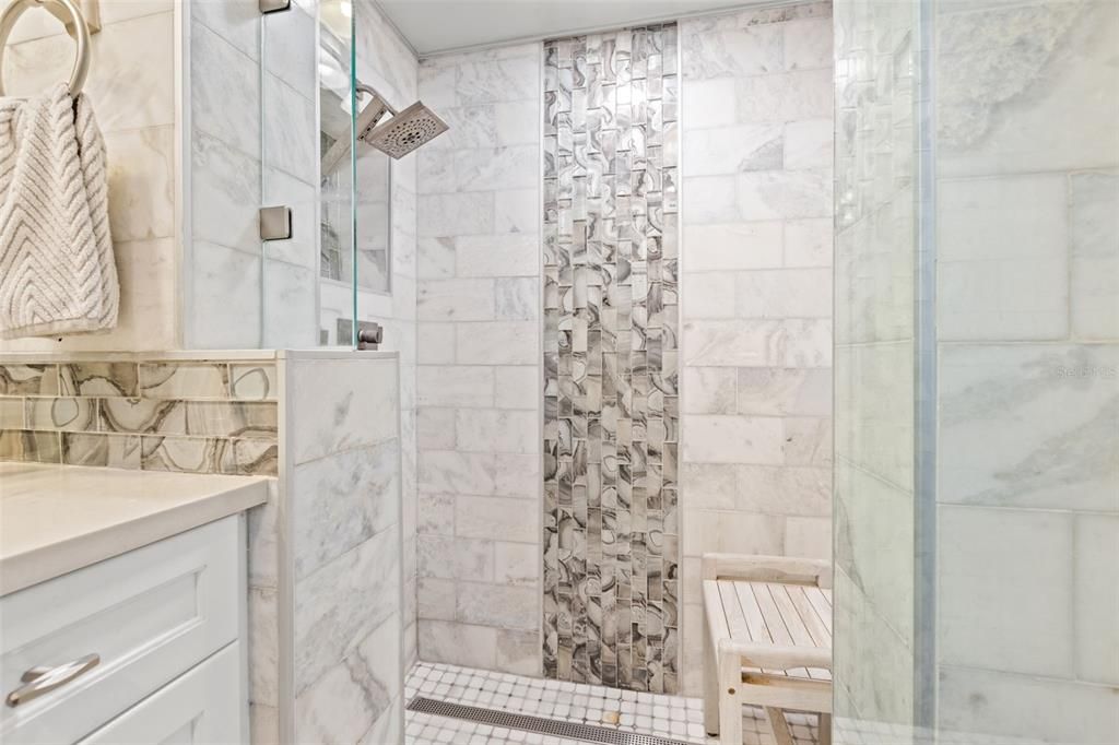 Master walk in shower with beautiful tile accents.