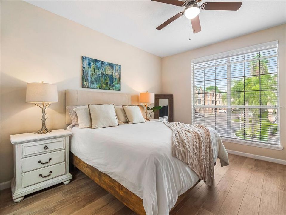 Master Bedroom has large window with lots of light and beautiful laminate flooring.