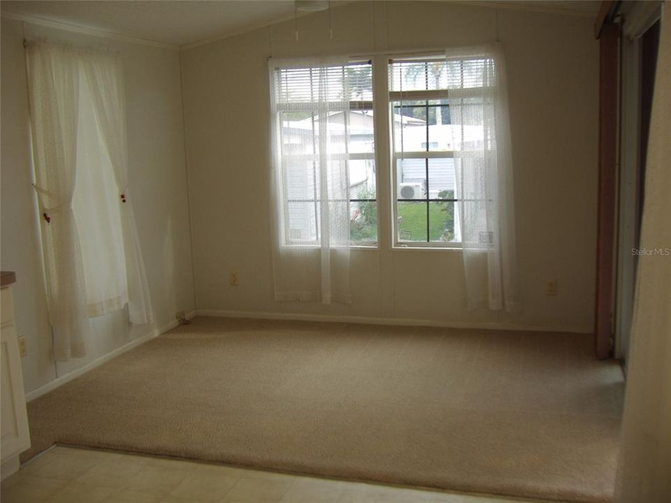 Nice clean carpeted Living room at the front with sliding glass doors entry