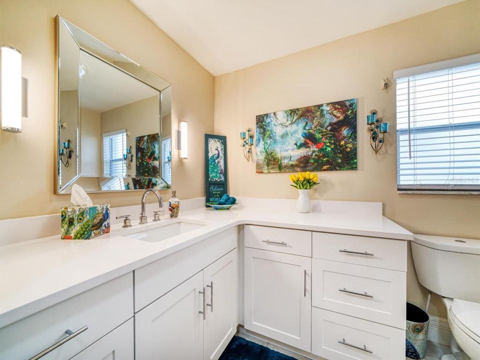 Recent remodeled bathroom services additional bedrooms showcasing attractive neutral cabinetry  and counters.