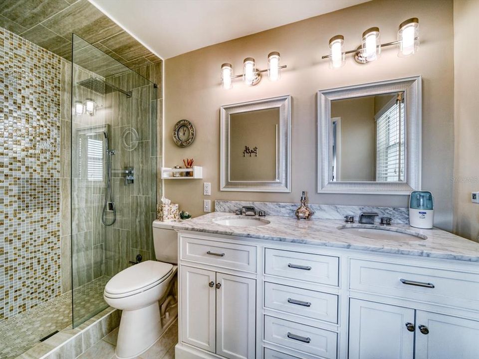Master bath has been extensively remodeled with gleaming marble vanity, dual sinks, and walk in shower  with extensive tile.