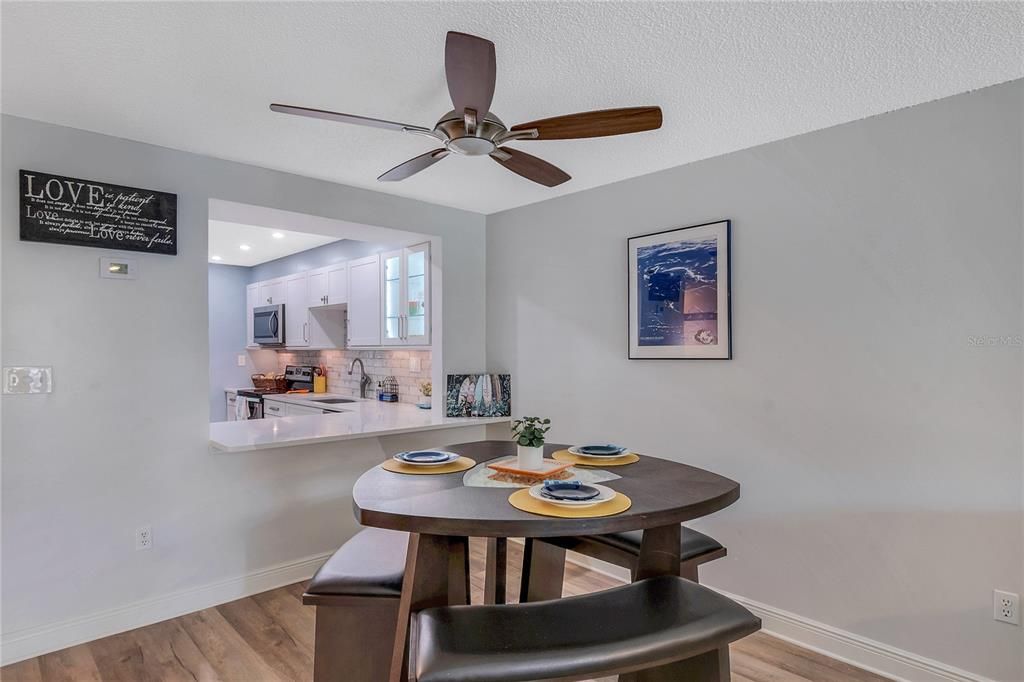 The dining area features a ceiling fan and breakfast bar.