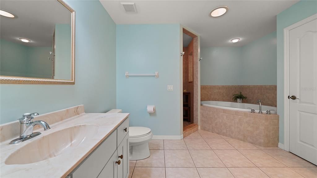 En suite bath has garden tub and separate walk in shower with two shower heads.