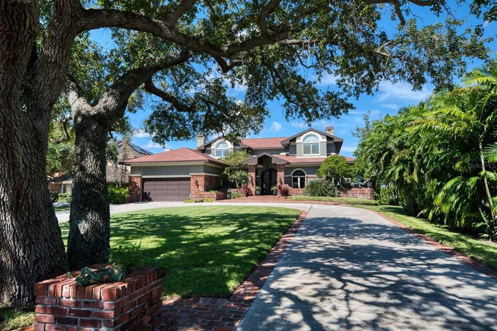 Approached by a circular drive, this private waterfront estate in Kensington Oaks is stunning!