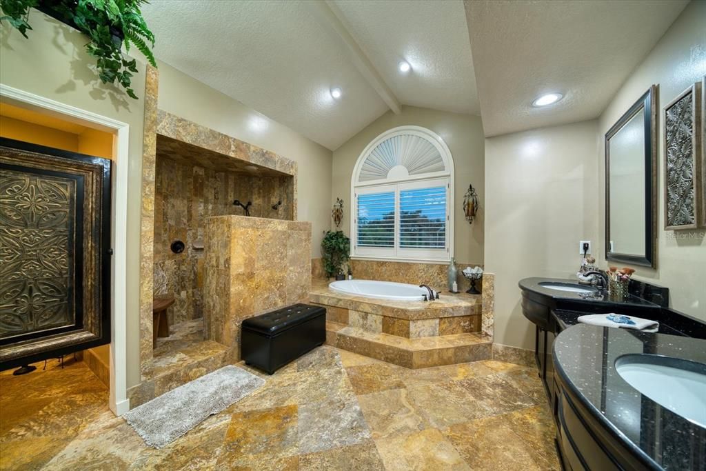 Master bath has detailed Travertine stone work, large walk in shower, separate soaking tub and separate water closet. Gorgeous access door!