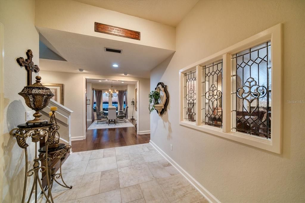 Wide entry foyer has natural light through leaded glass windows of the adjacent living room.