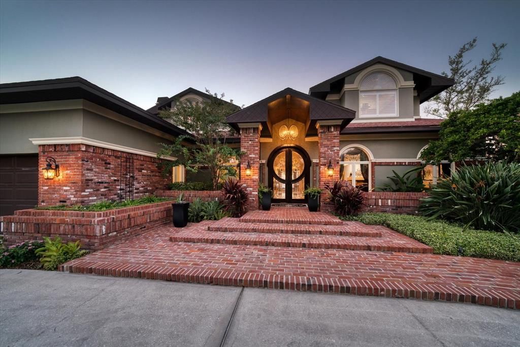 Sophisticated double door entry with brick paver terraced approach- Exquisite in all details!