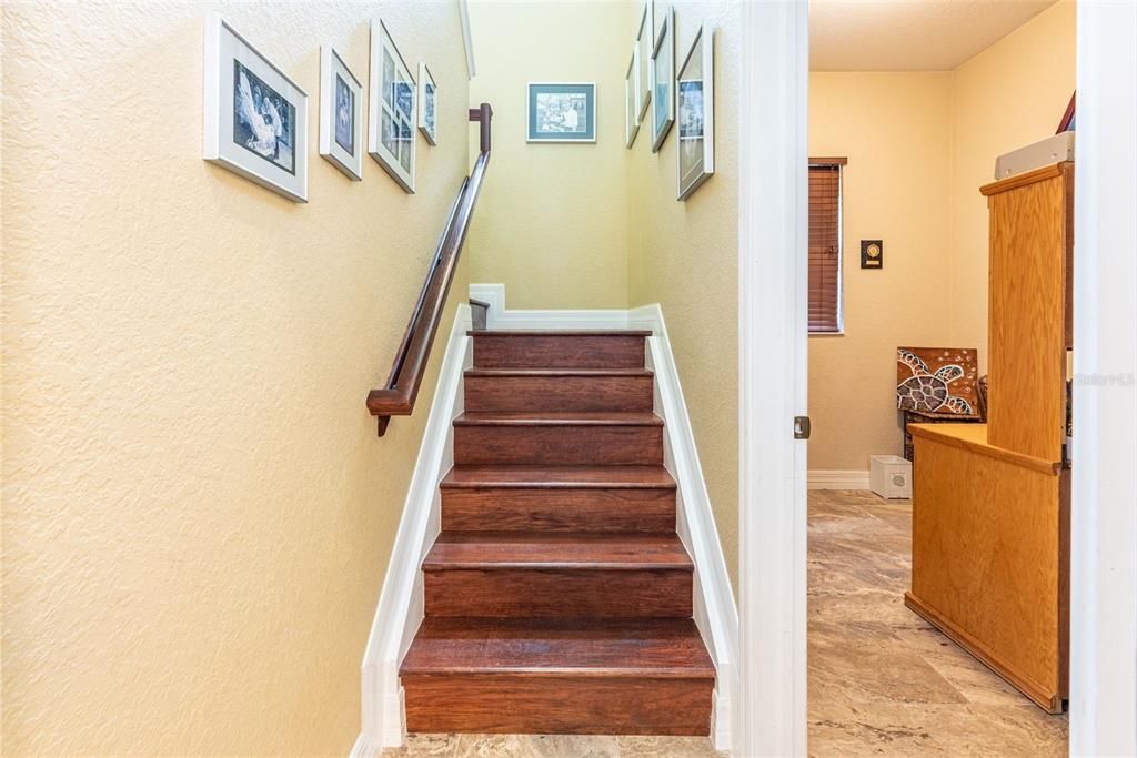 Stairs to bonus room plus partial view of additional storage room or office